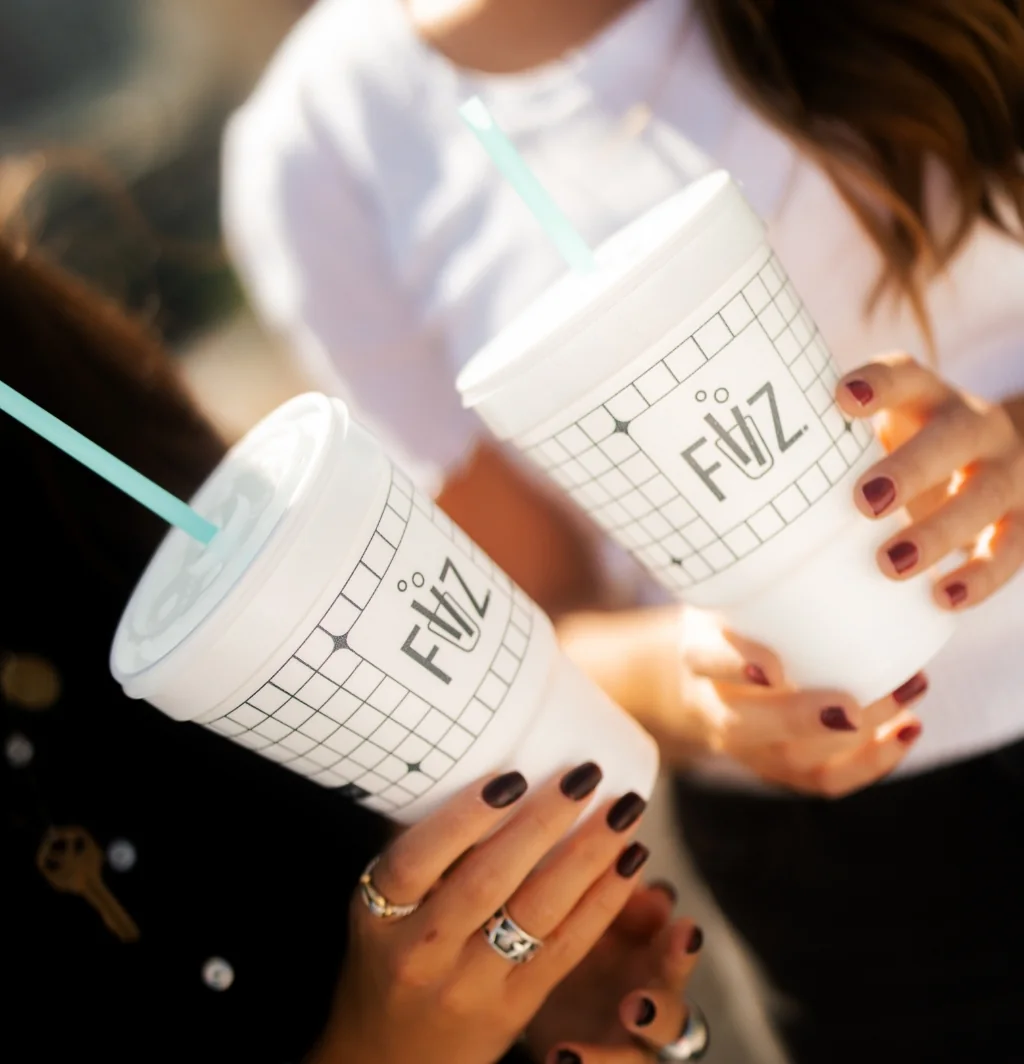 Colorful FIIZ drinks raised together